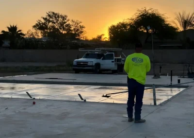 A Belco crew member and truck on a finished slab at sunset