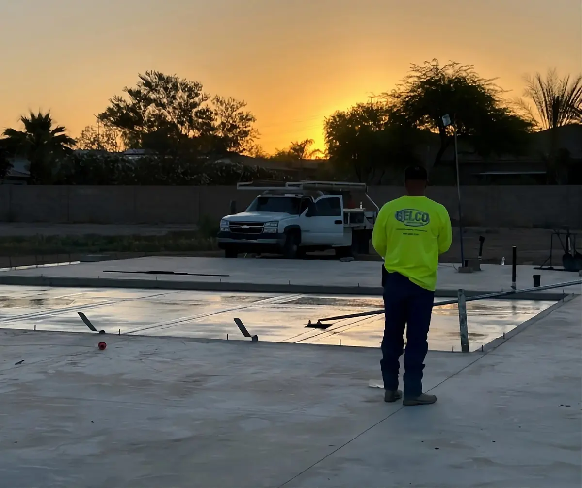 A Belco crew member and company truck on a finished concrete slab at sunset
